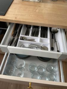 a kitchen drawer filled with dishes and utensils at Vilkmerge apartment in Ukmergė