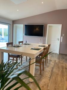 a dining room with a table and chairs and a tv at Ferienhaus mit privatem Pool in Soltau +7 photos