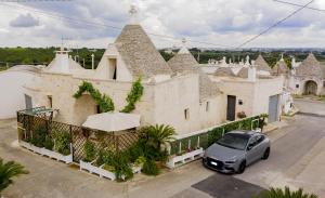 un coche aparcado delante de un edificio en Trulli Balè, en Locorotondo