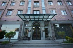 un grand bâtiment en briques avec une porte tournante dans l'établissement 4Guest Hotel, à Erevan