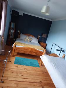 sypialnia z łóżkiem i niebieską ścianą w obiekcie graiguenamanagh Homestay w mieście Graiguenamanagh
