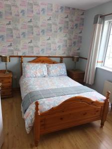 sypialnia z drewnianym łóżkiem z drewnianym zagłówkiem w obiekcie graiguenamanagh Homestay w mieście Graiguenamanagh