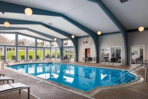 a large pool with blue water in a building at Howard Johnson by Wyndham Middletown Newport Area in Middletown