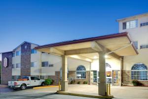 a building with a covered parking lot in front of it at Super 8 by Wyndham Kansas City in Kansas City