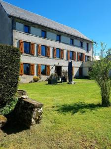 MesseixにあるVacances à la Campagne 4 étoiles à 30min des pistes de ski Mont Dore Sancyの前に芝生がある大きな建物