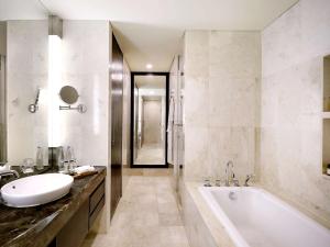 ein Badezimmer mit einer Badewanne und einem Waschbecken in der Unterkunft Pullman Bali Legian Beach in Legian