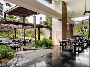 a restaurant with tables and chairs in a building at Pullman Bali Legian Beach in Legian