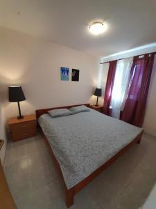 a bedroom with a bed and two night stands and two lamps at Apartment Mihael - 4 persons in Vodnjan