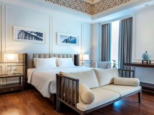 a bedroom with a bed and a couch at Novotel Phuket City Phokeethra in Phuket Town