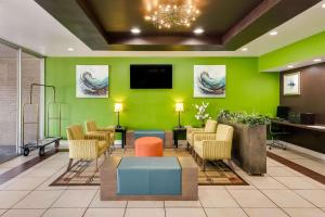 poczekalnia z zielonymi ścianami i krzesłami oraz telewizorem w obiekcie Clarion Inn & Suites Russellville I-40 w mieście Russellville