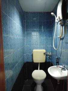 a blue tiled bathroom with a toilet and a sink at KL CITY LODGE in Kuala Lumpur