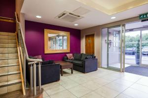 a living room with purple walls and a couch at Clarion Hotel Newcastle South in Sunderland