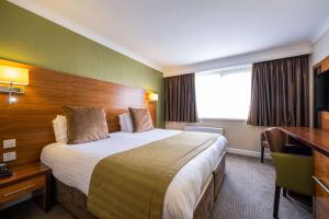 a hotel room with a large bed and a desk at Clarion Hotel Newcastle South in Sunderland