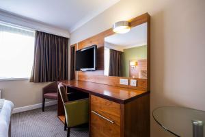 een hotelkamer met een bureau en een spiegel bij Clarion Hotel Newcastle South in Sunderland