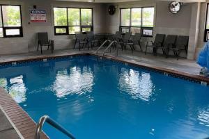 a large swimming pool with chairs and a table at Comfort Inn Indianapolis South I-65 in Indianapolis