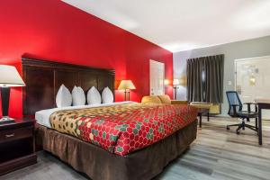 Habitación de hotel con cama y pared roja en Econo Lodge Inn & Suites en Filadelfia