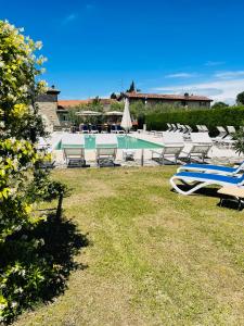a pool with lounge chairs and a bunch ofitures at Cà Donzella in Lazise
