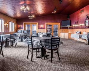 a dining room with tables and chairs and a tv at Quality Inn & Suites Munising in Wetmore