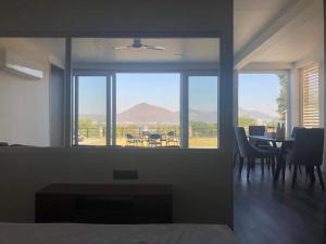 Una habitación con una mesa y sillas y una ventana grande. en Grace Villa, en Udaipur