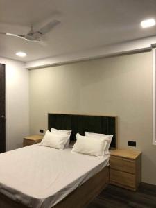 Un dormitorio con una cama grande con sábanas y almohadas blancas. en Grace Villa, en Udaipur 5 fotos más