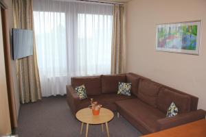 een woonkamer met een bank en een tafel bij Hotel Estella Superior in Eger