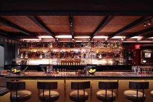 纽约Martinique New York on Broadway, Curio Collection by Hilton的酒吧里有很多瓶装酒精饮料