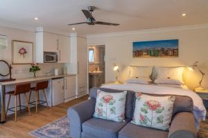 Cet appartement comprend une chambre avec un lit et un canapé ainsi qu'une cuisine. dans l'établissement Hedge House Guest House, au Cap