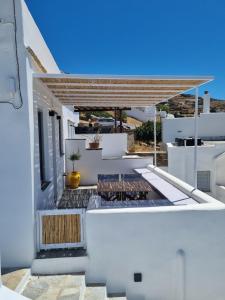 a white house with white walls and a roof at Màrgaros House Tinos in Triandáros