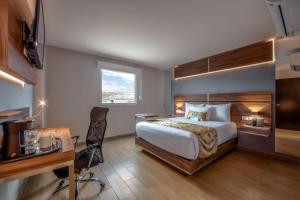 Sleep Inn Tijuana في تيخوانا: غرفة نوم بسرير ومكتب وكرسي