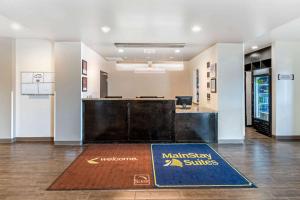 una oficina con una alfombra de bienvenida en medio de un vestíbulo en MainStay Suites Denver International Airport en Denver