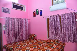 a pink bedroom with a bed and a window at Hari Suman Paying Guest house in Ayodhya