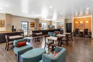 丹佛的住宿－MainStay Suites Denver International Airport，一间带桌椅的餐厅和一间酒吧