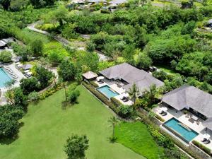 - une vue aérienne sur une maison avec une piscine dans l'établissement Raffles Bali, à Jimbaran