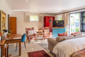 um quarto com uma cama e uma sala de estar em Hedge House Guest House na Cidade do Cabo