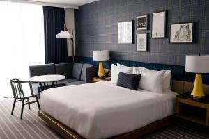 薩默維爾的住宿－Cambria Hotel Boston Somerville，酒店客房设有一张大床和一张桌子。