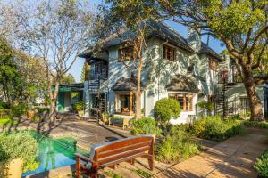 una casa con un banco junto a una piscina en Hedge House Guest House en Ciudad del Cabo