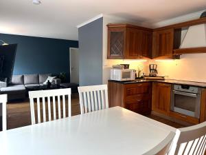 a kitchen and living room with a white table and chairs at Ålesund Urban - Spacious and luminous 100 m2 urban flat with 3 large bedrooms in Ålesund +20 photos