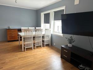 a living room with a dining room table and chairs at Ålesund Urban - Spacious and luminous 100 m2 urban flat with 3 large bedrooms in Ålesund