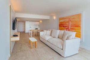 Radisson Blu Aruba في شاطئ بالم إيغل: غرفة معيشة مع أريكة بيضاء وطاولة