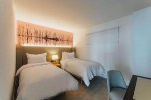 um quarto com 2 camas, uma cadeira e uma fotografia em Radisson Blu Aruba em Palm-Eagle Beach
