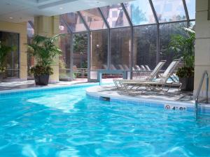 a swimming pool in a hotel with two chairs and a table at Homewood Suites By Hilton Downers Grove Chicago, Il in Downers Grove