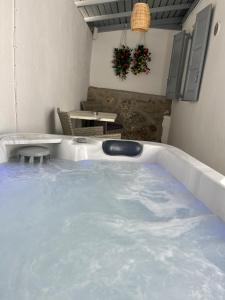 eine Whirlpool-Badewanne auf einer Terrasse mit einem Tisch in der Unterkunft Mykonos Secret Spot in Mykonos Stadt
