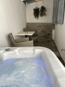 uma banheira de hidromassagem num quarto com uma mesa e cadeiras em Mykonos Secret Spot em Míconos