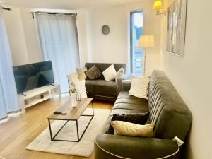 a living room with a couch and a table at Sleeps 4 - Private Balcony - Wheelchair Accessible in London