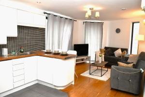 a kitchen and living room with a couch and a table at Sleeps 4 - Private Balcony - Wheelchair Accessible in London +7 photos
