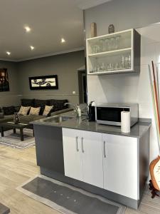 a kitchen with a sink and a living room at A casa da charca in Valga