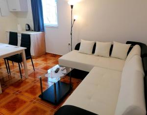 a living room with a white couch and a table at TRI KRALJA - THREE KINGS Apartments in the center with private parking in Imotski