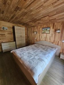 a bedroom with a large bed in a wooden room at Nameliai Šventojoje 2 in Palanga
