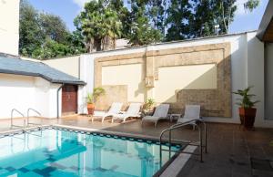 a swimming pool with chairs next to a building at The Heron By Sarovar Portico India in Nairobi