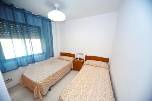 1 dormitorio con 2 camas y ventana en PLAYAMAR Superior Orangecosta, en Alcossebre
